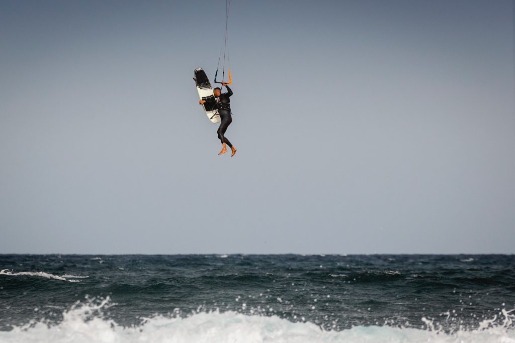 a kiteboarder performing a trick with a strapless freestyle board